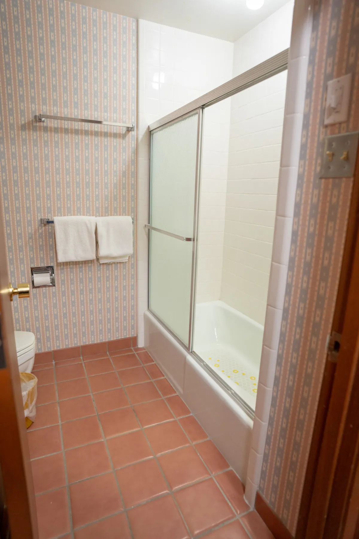A modern bathroom with tiled floors, a glass-enclosed shower area, and plush towels creates a spa-like atmosphere. The space feels bright, clean, and refreshing—ideal for morning routines or post-adventure unwinding.